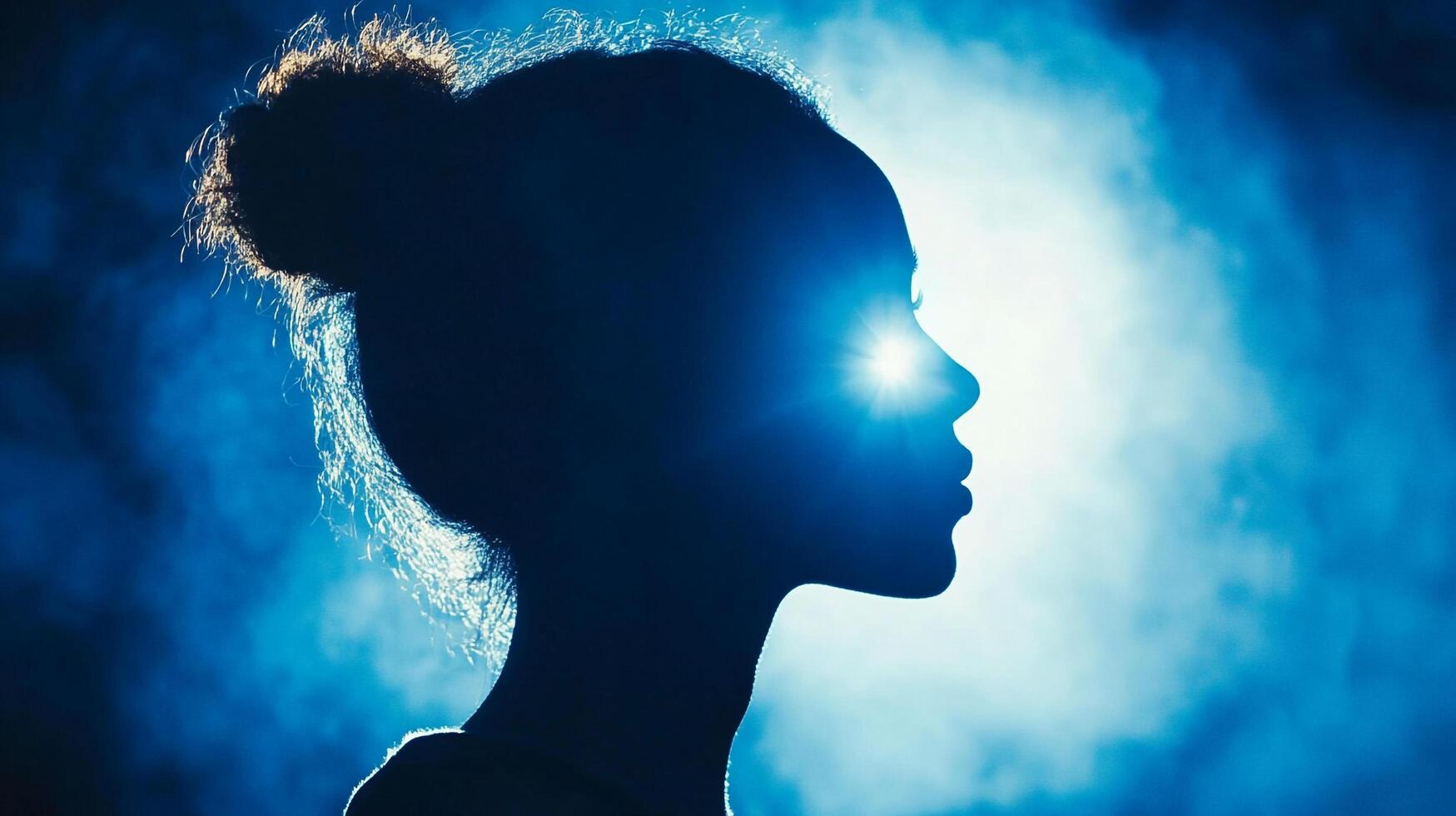 Profile of a woman, with light emanating from her forehead, set against a blue background creating a dreamy, ethereal atmosphere. photo