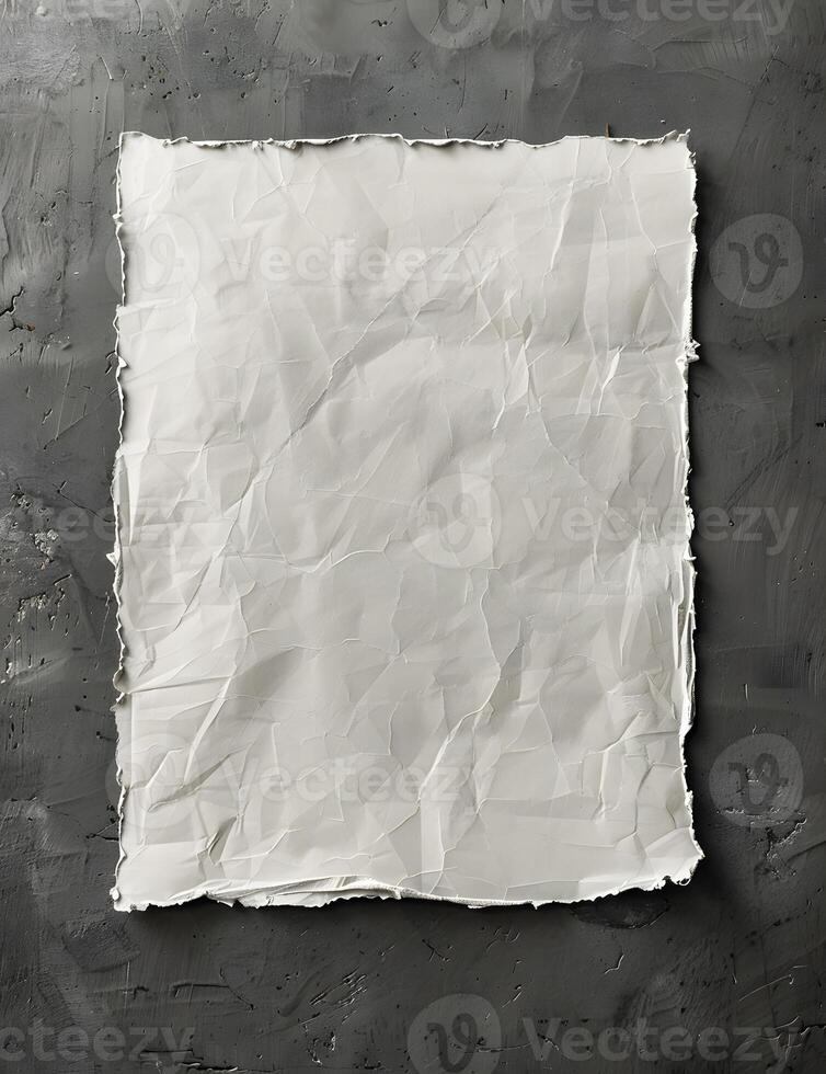 A torn paper rests on a grey surface in a monochrome photography event photo