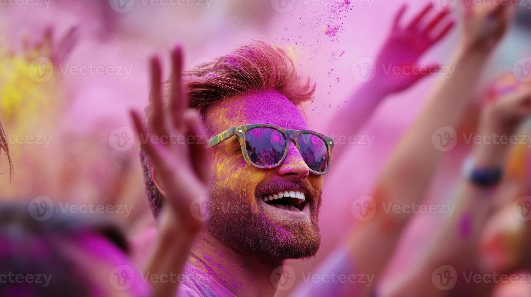 A man with sunglasses and a beard is covered in colored powder photo