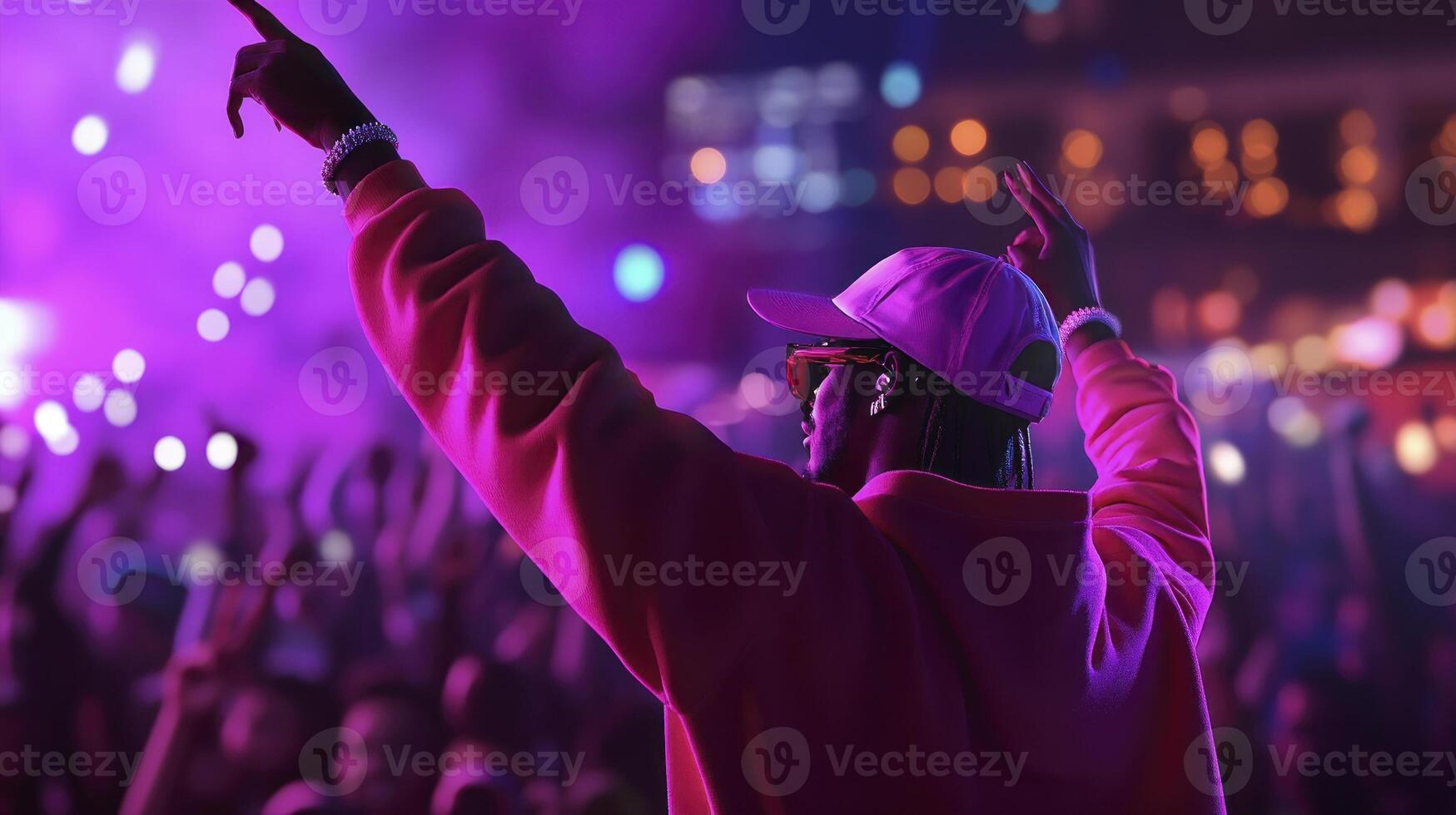 A man in a pink hoodie is at a concert photo