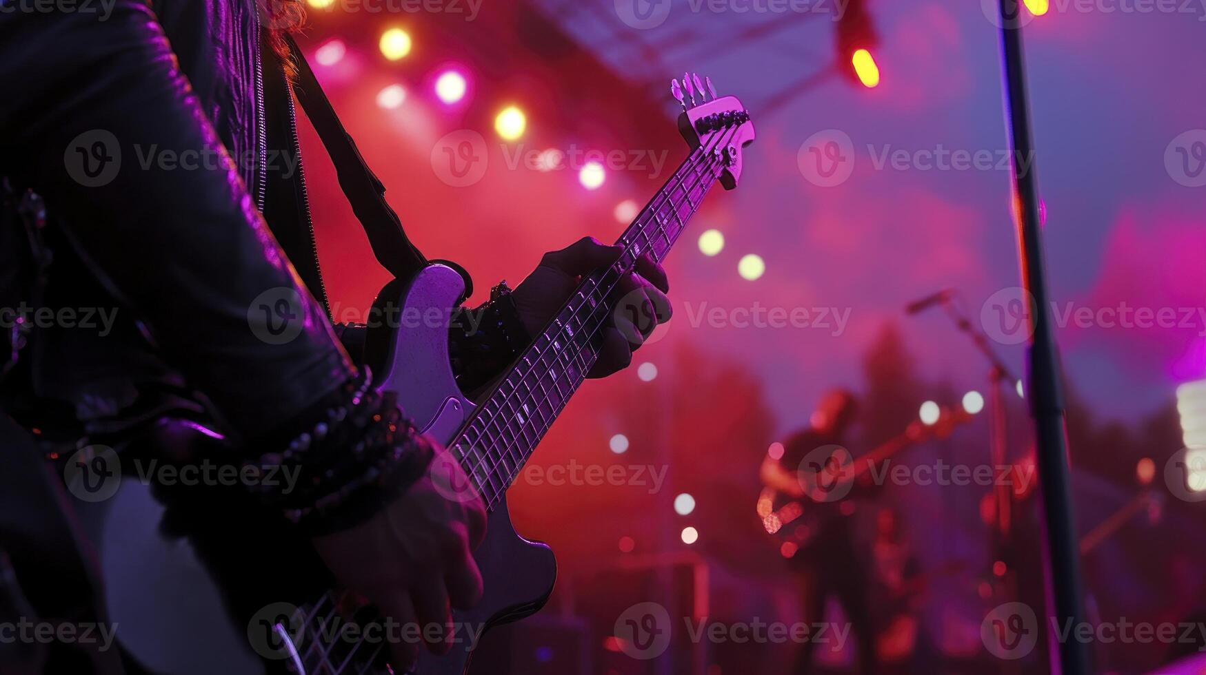 A person playing an electric guitar at a concert photo