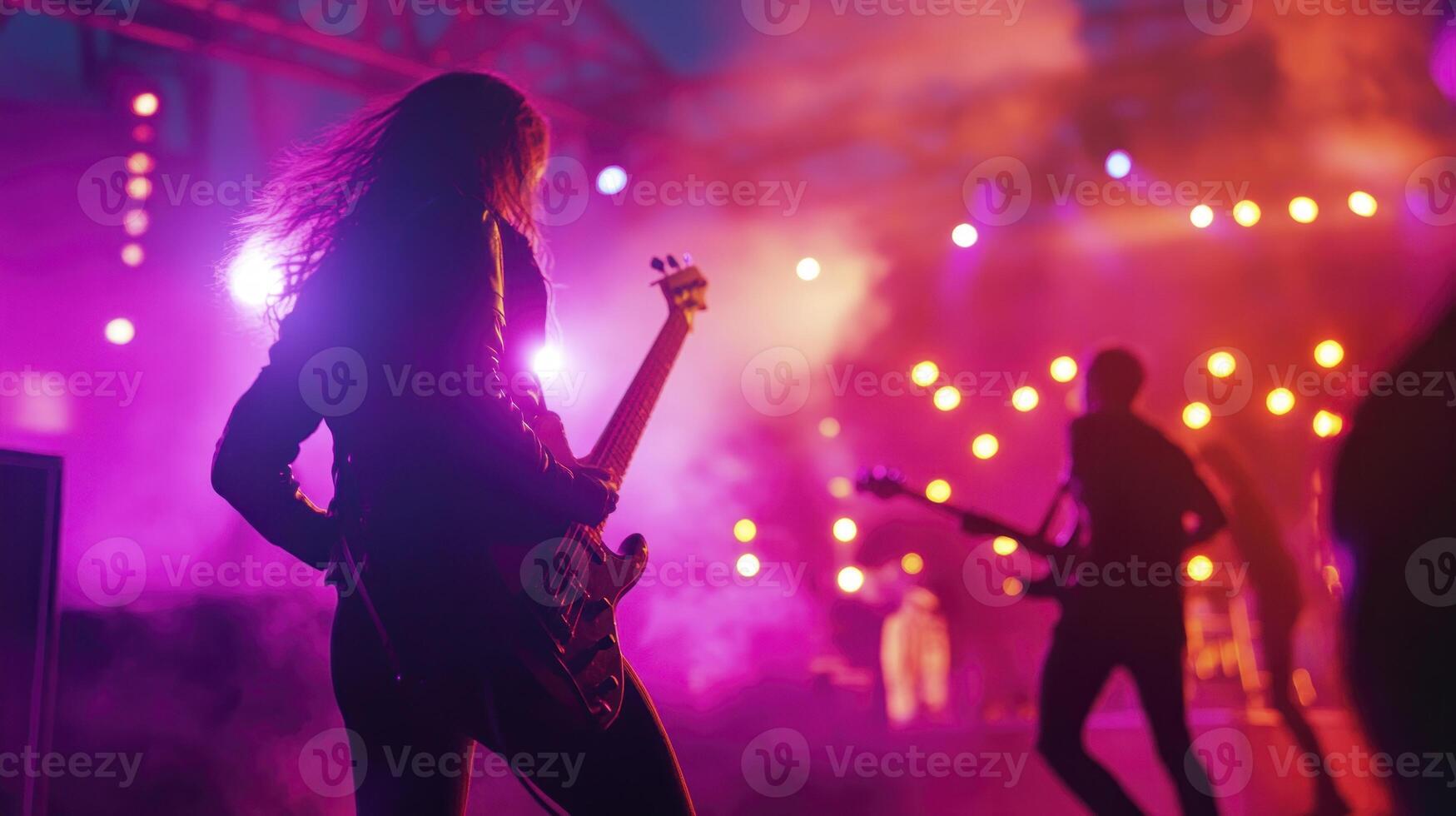 A group of people playing guitar on stage photo