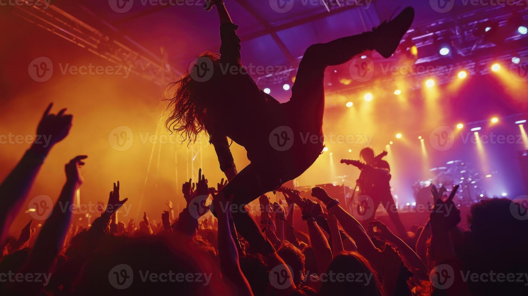 A crowd of people at a concert with a person in the air photo