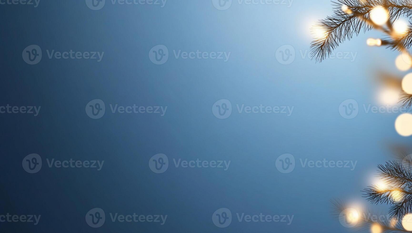 A serene blue background with soft lights and pine branches. photo