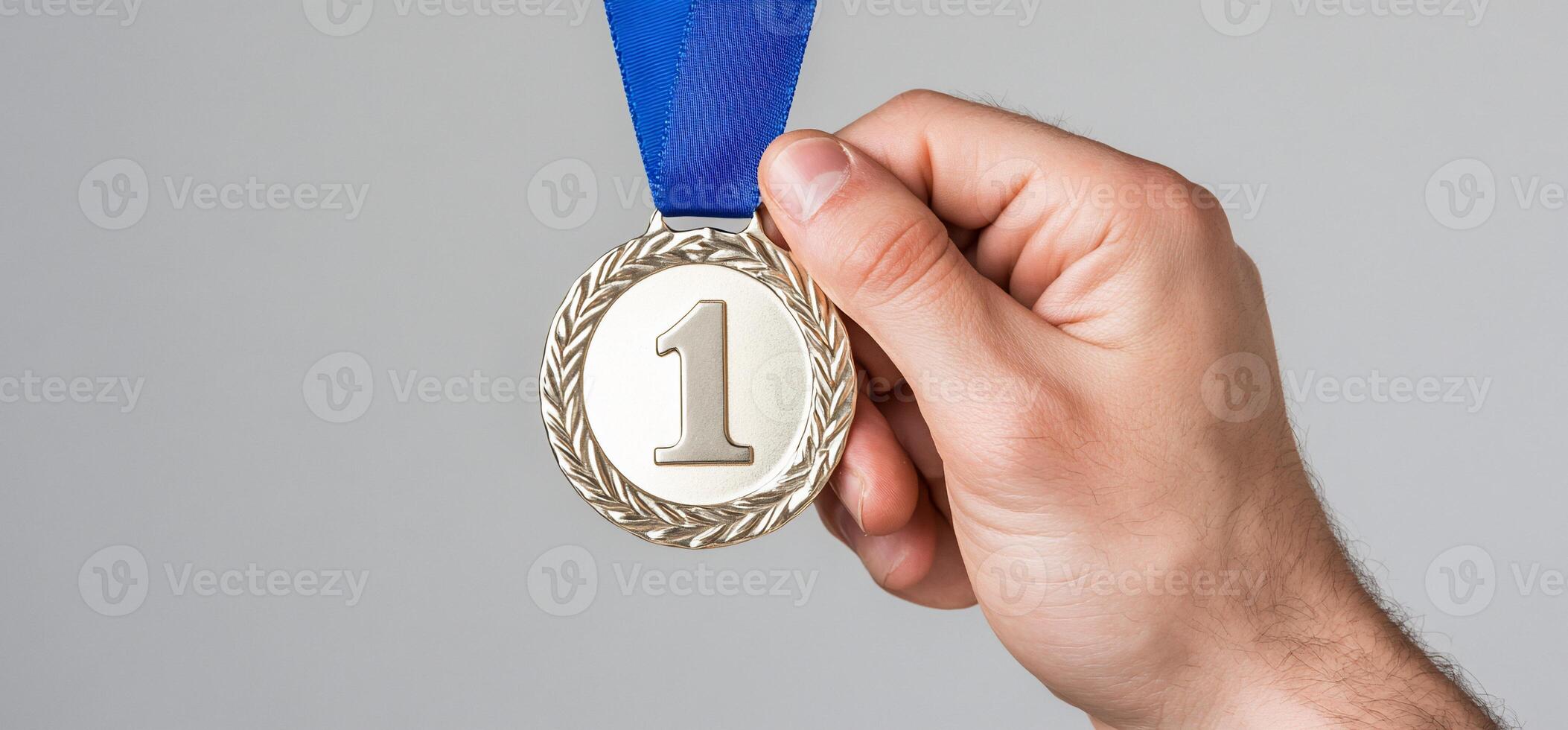 A hand holding a first-place medal with a blue ribbon. photo