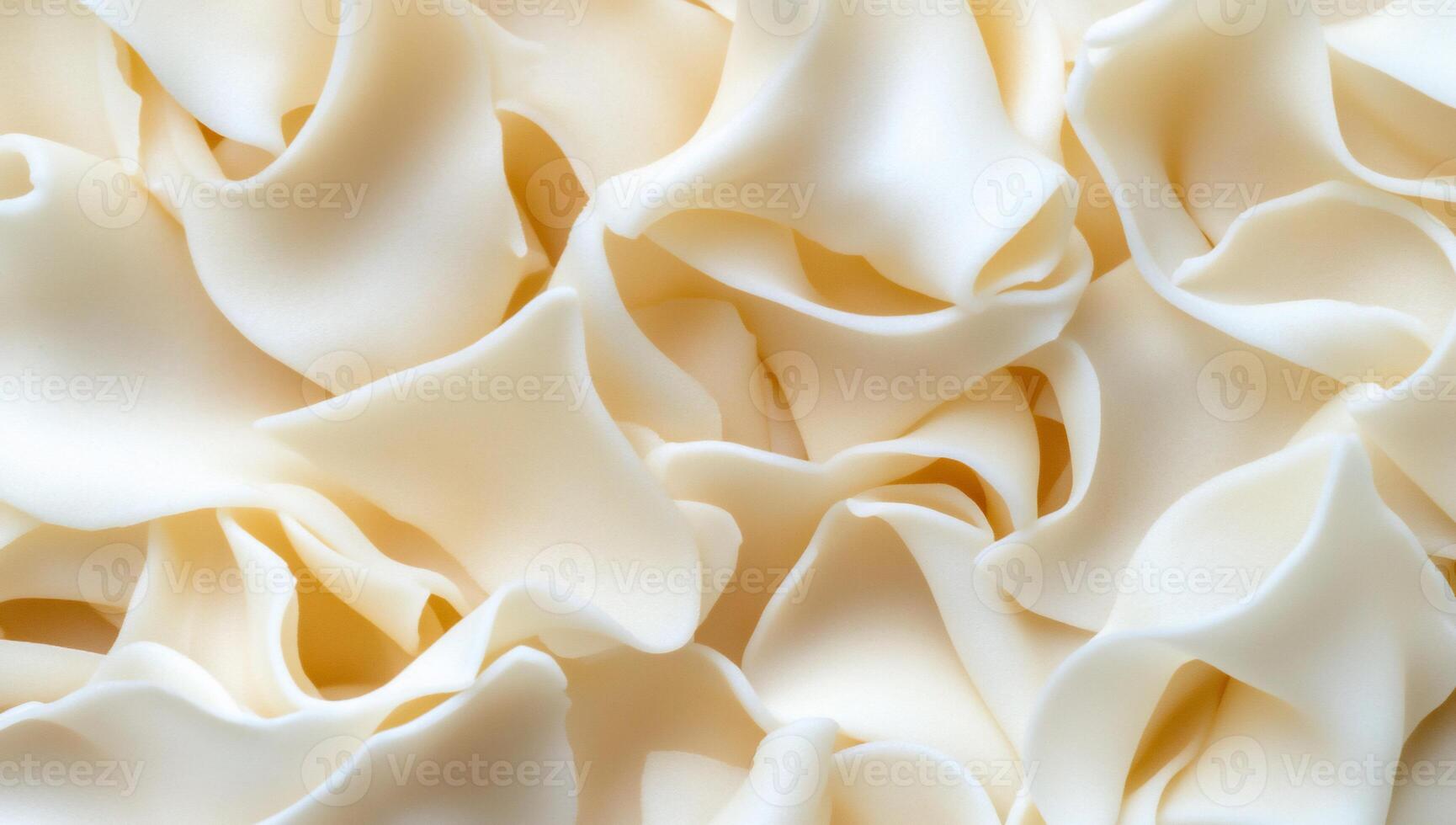 A close-up view of soft, cream-colored fabric with flowing folds. photo