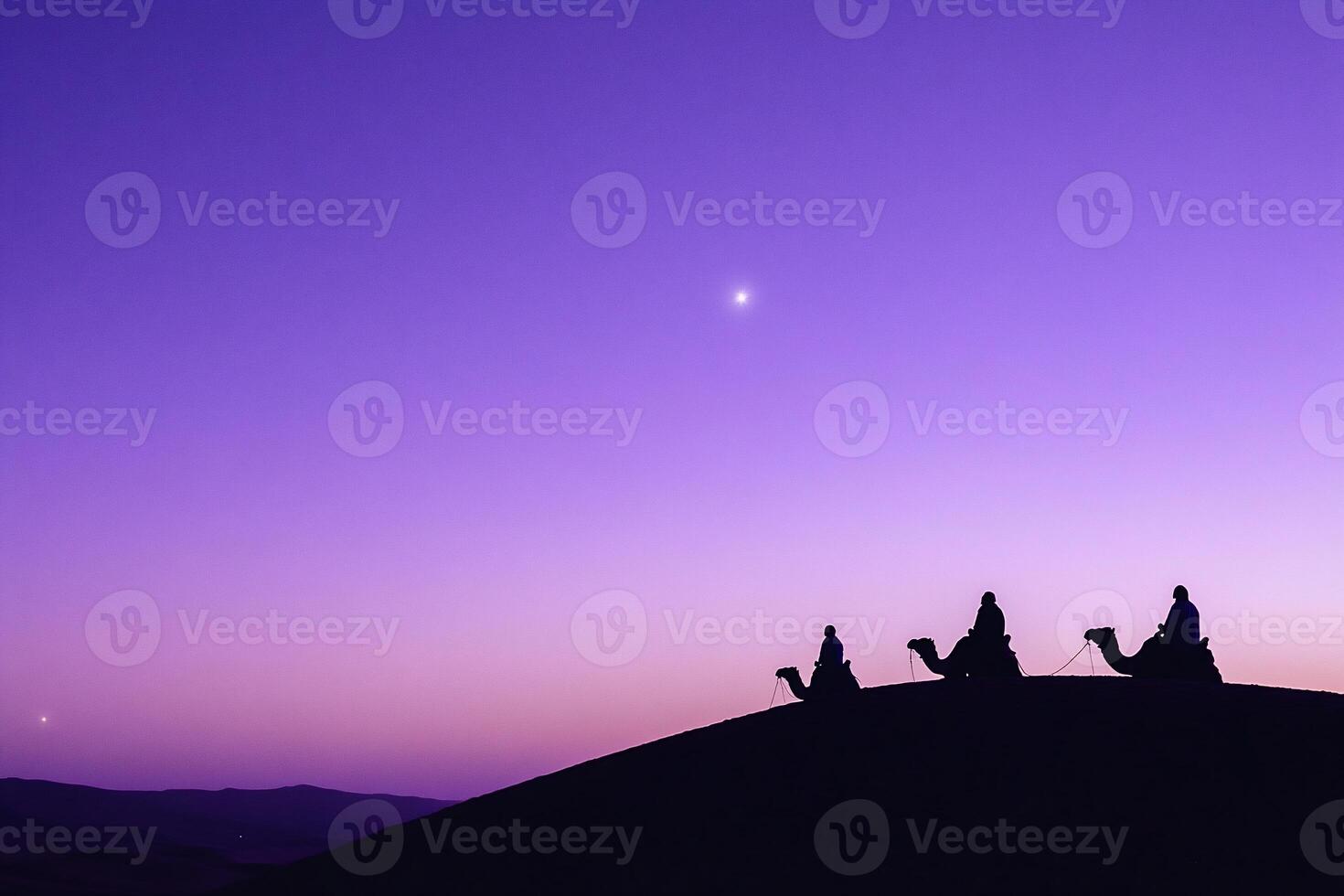 Three people on camels are silhouetted against a purple sky photo