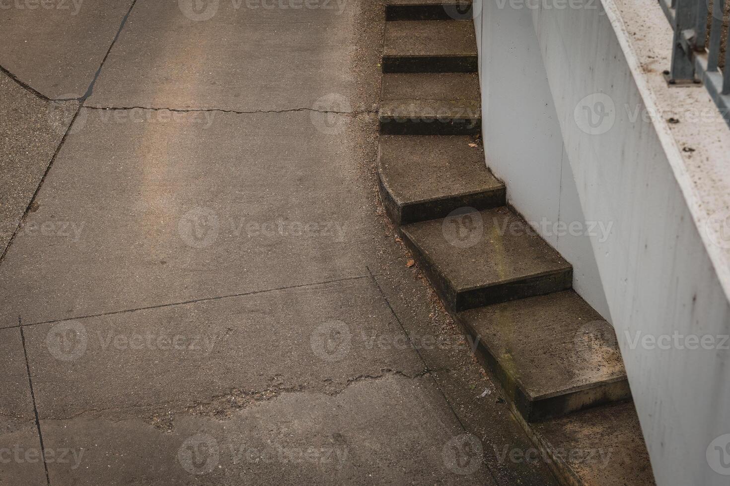Stairway leading down a curved path in an urban setting with concrete textures in the late afternoon light photo