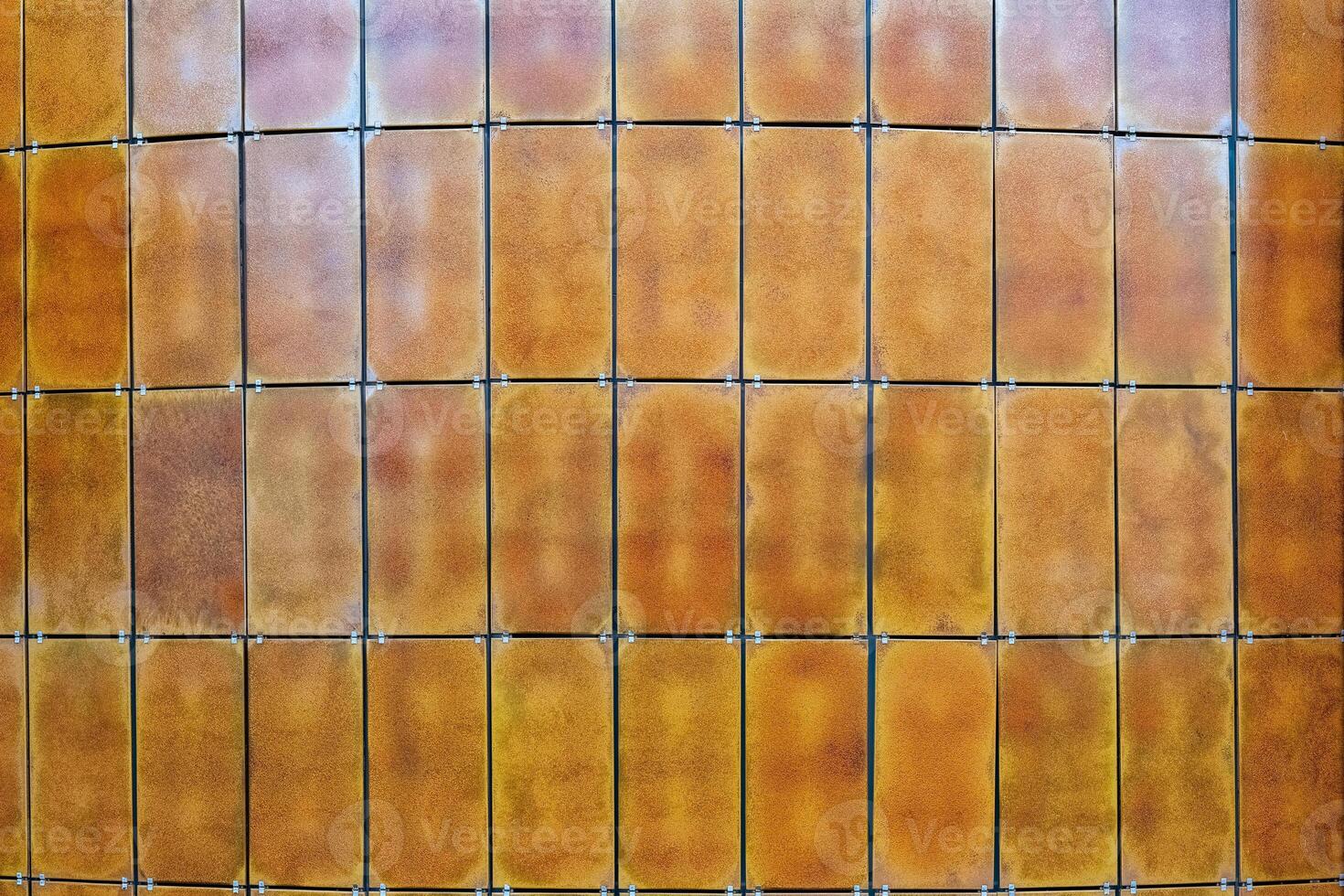 Rustic metal panels create a striking textured wall in an urban environment during the afternoon light photo