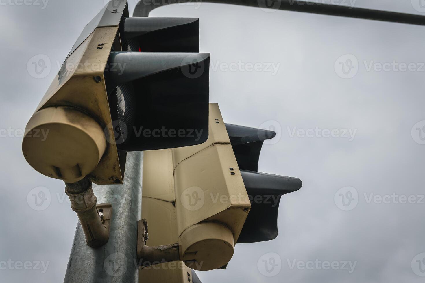Traffic signal against a cloudy sky in an urban environment indicating stop and go for vehicles and pedestrians photo