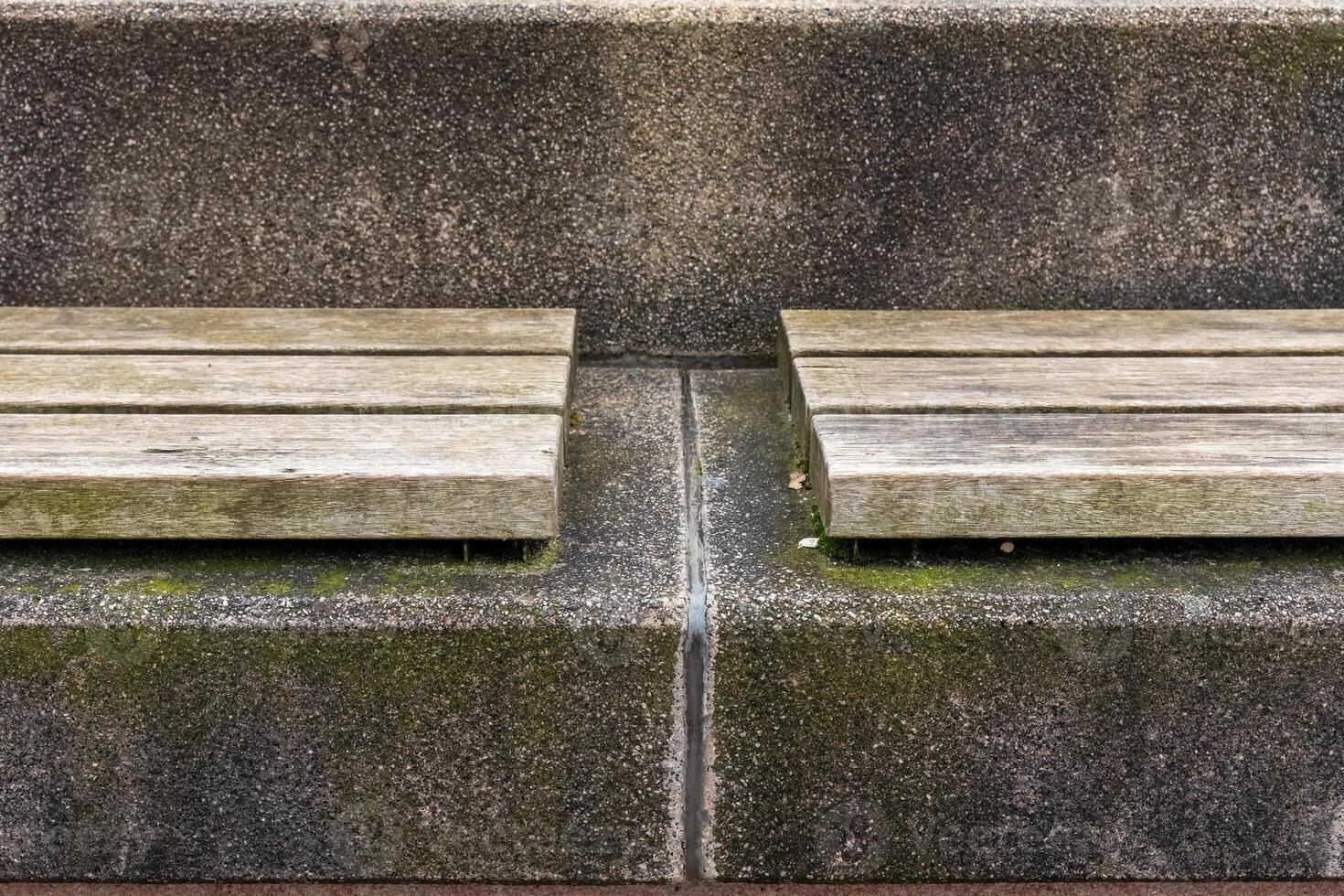 Unique bench design featuring wooden slats and textured concrete structure in an outdoor urban setting photo