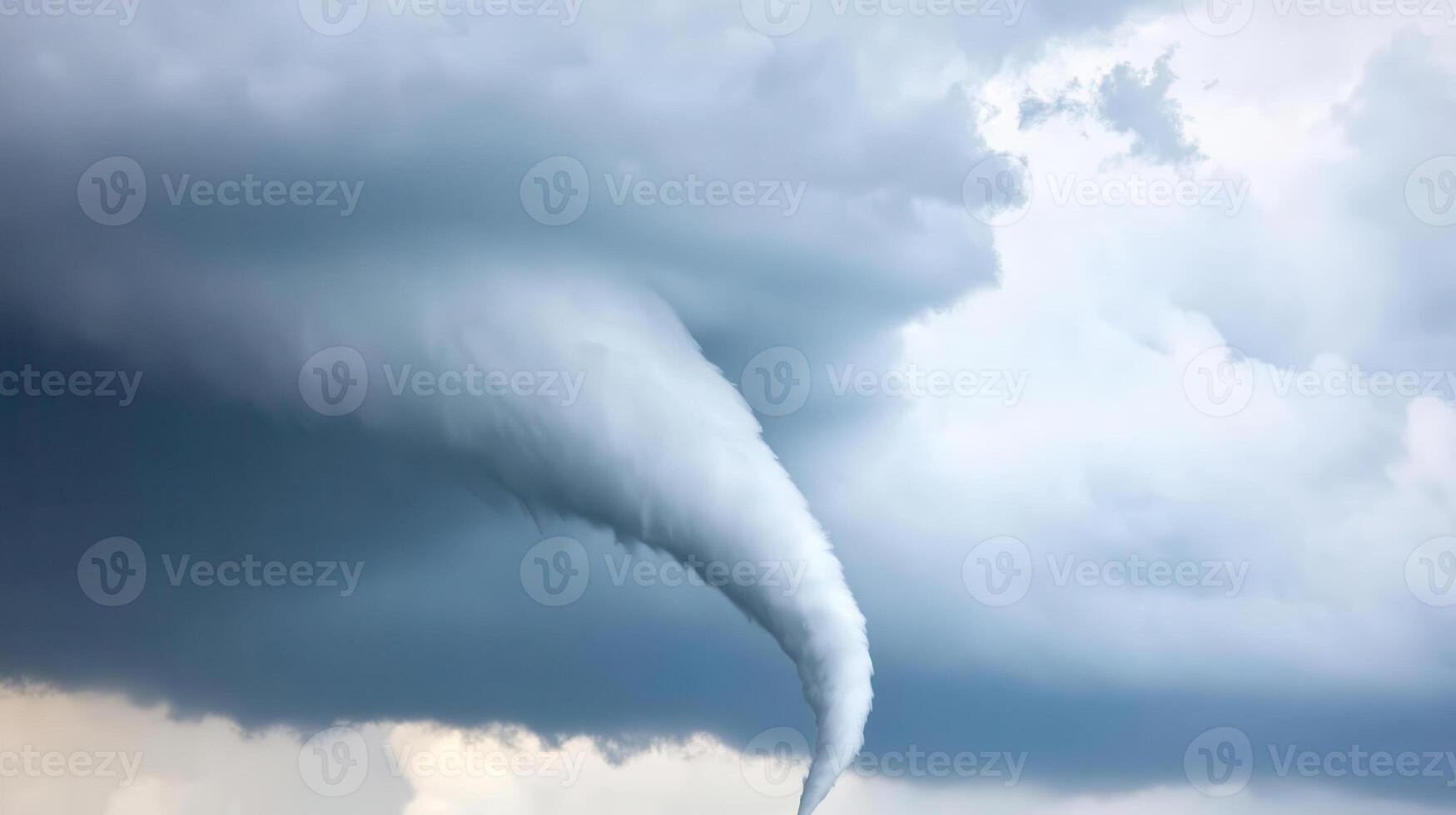 A tornado is seen in the sky above a field photo