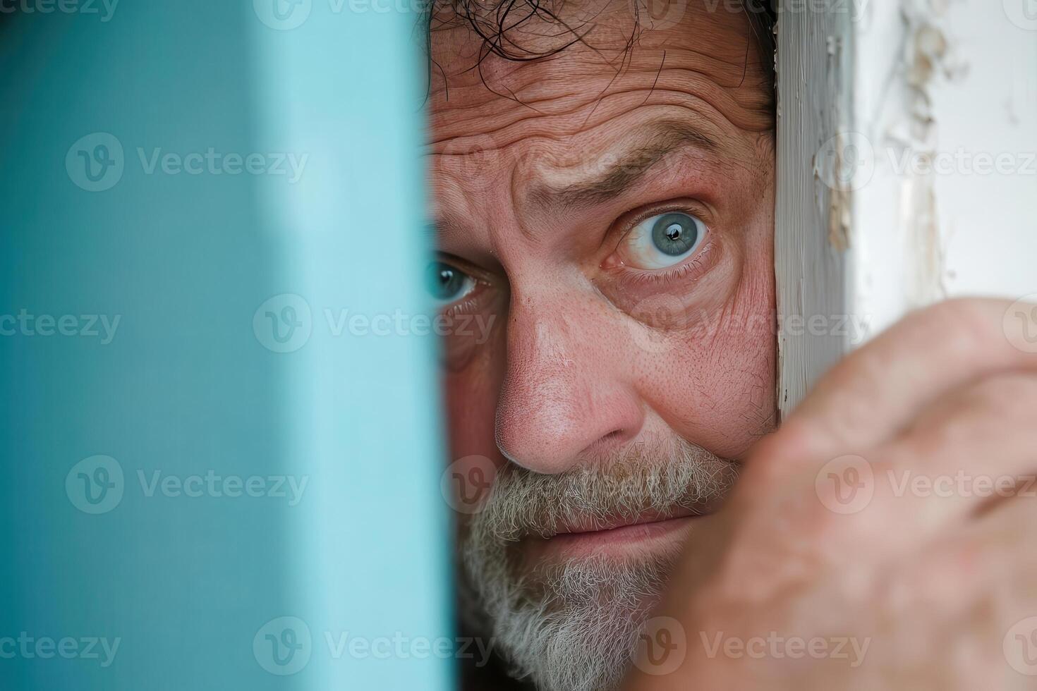 A man peeking out from behind a door photo
