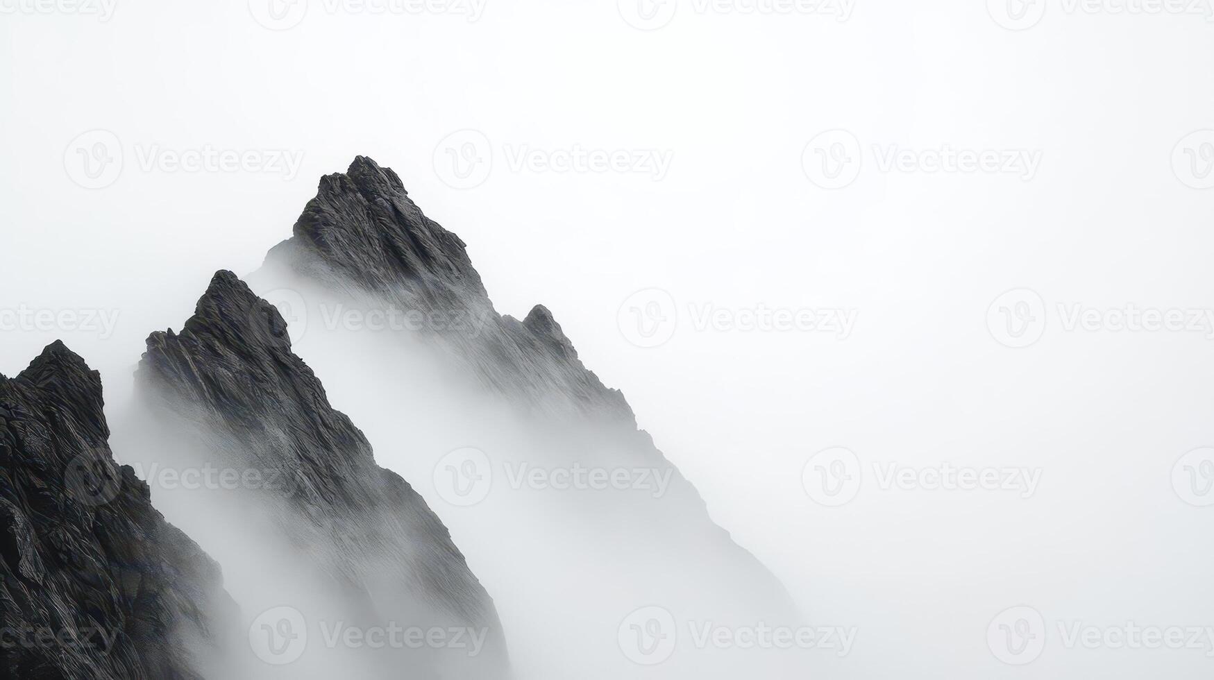 A monochrome mountain silhouette stands out against a deep foggy sky, casting a soft light and creating a dramatic atmosphere. photo