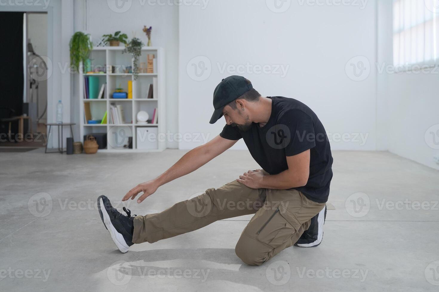 Young man energetically stretching for fitness in a spacious, minimalistic urban studio environment photo