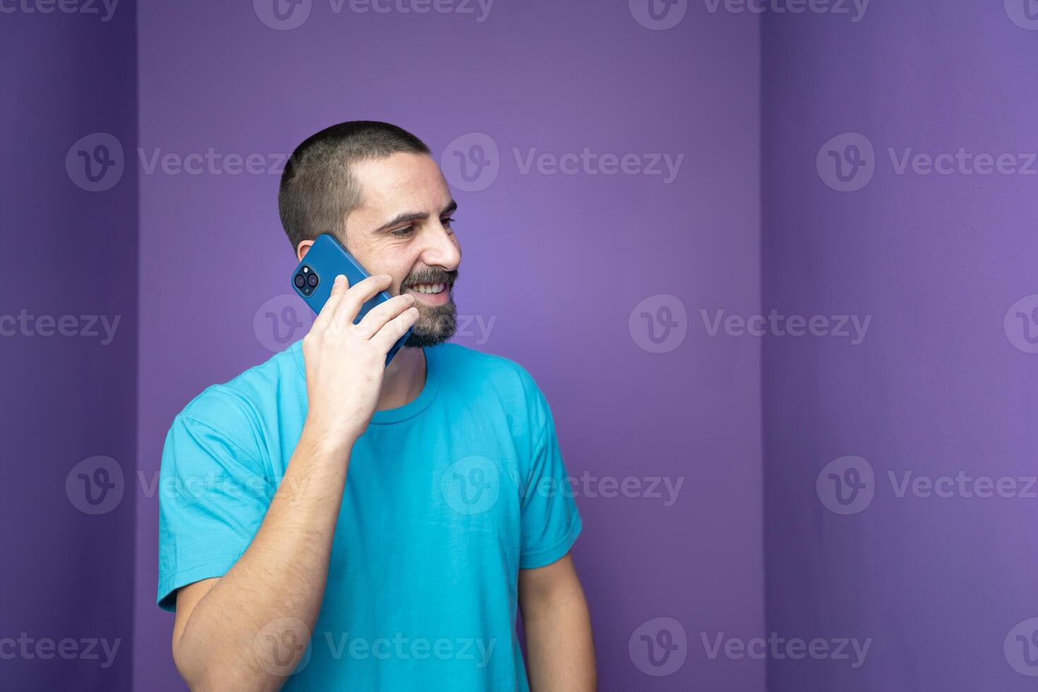 A young man engaged in a phone conversation within a vibrant and colorful purple room, photo