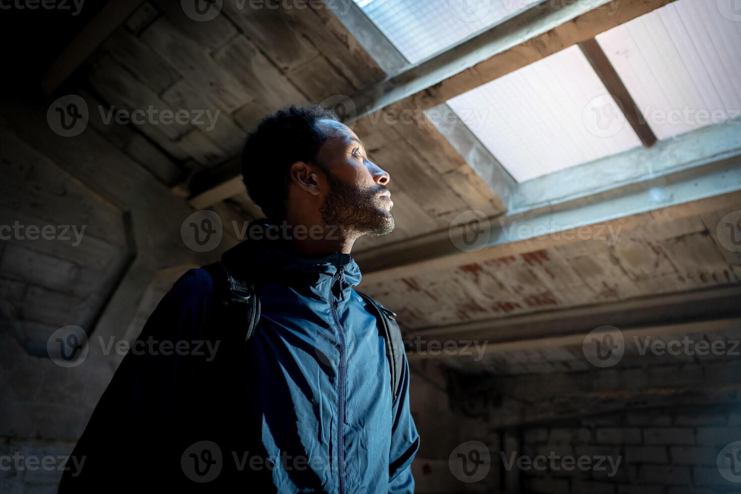A man gazing upward at a beautiful skylight window set within an industrial themed environment photo