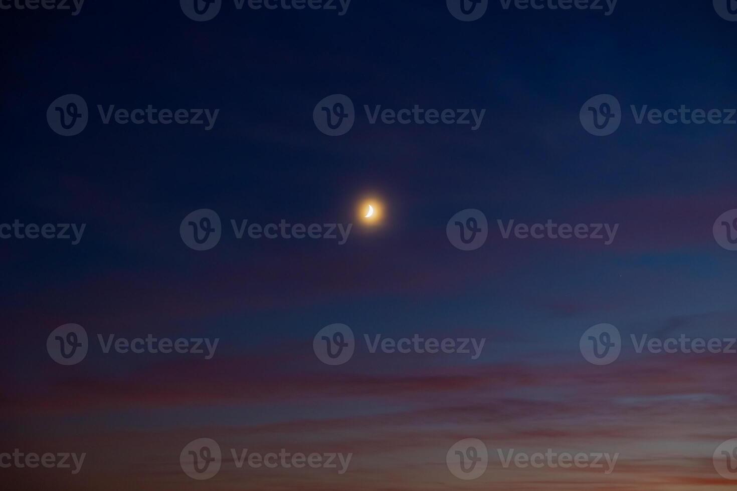Glowing crescent moon on the hazy sky. Ramadan concept photo