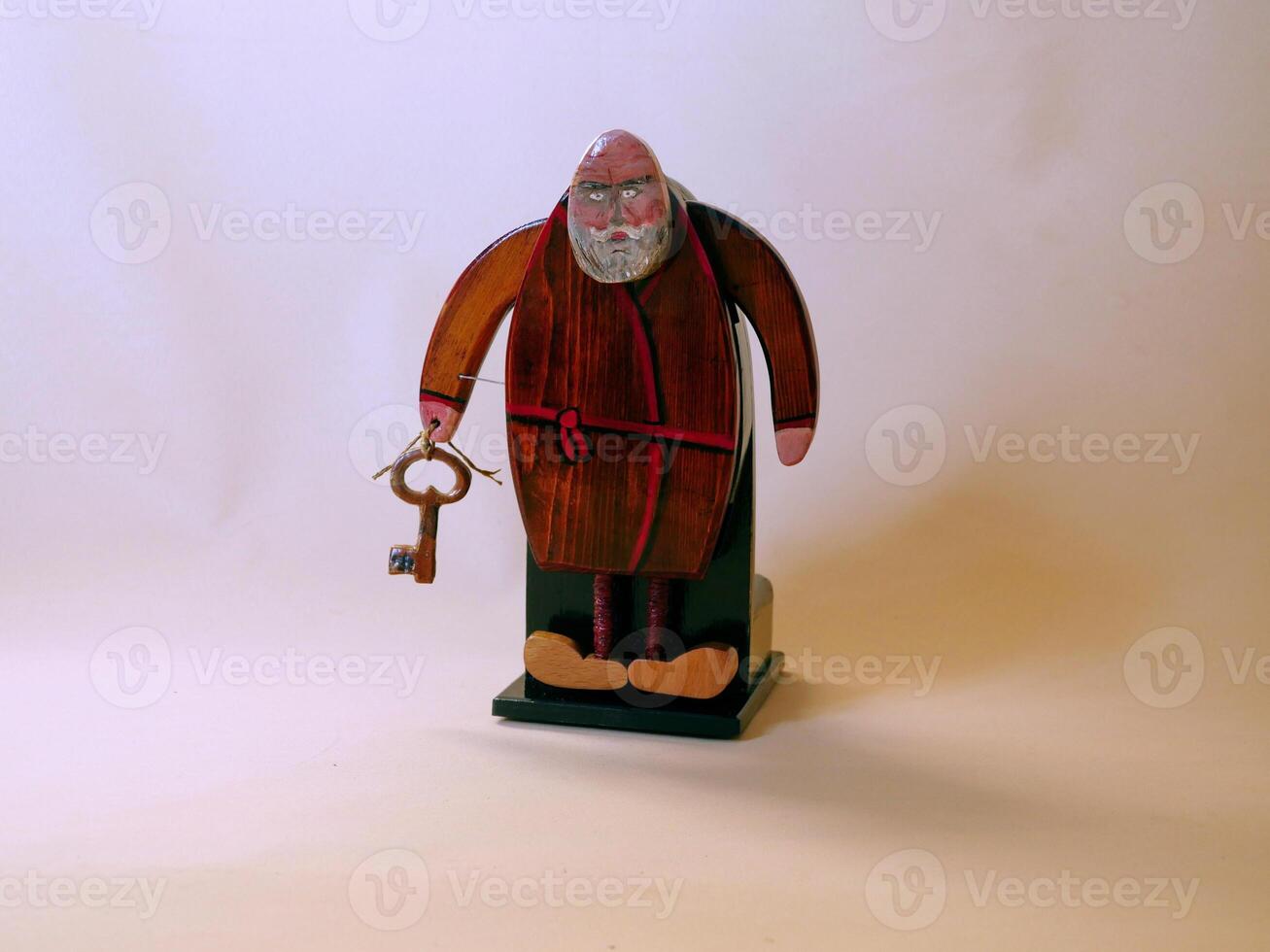 Apostle Peter, a bearded old man in a toga, with a large key to the kingdom of heaven, wooden figurine photo