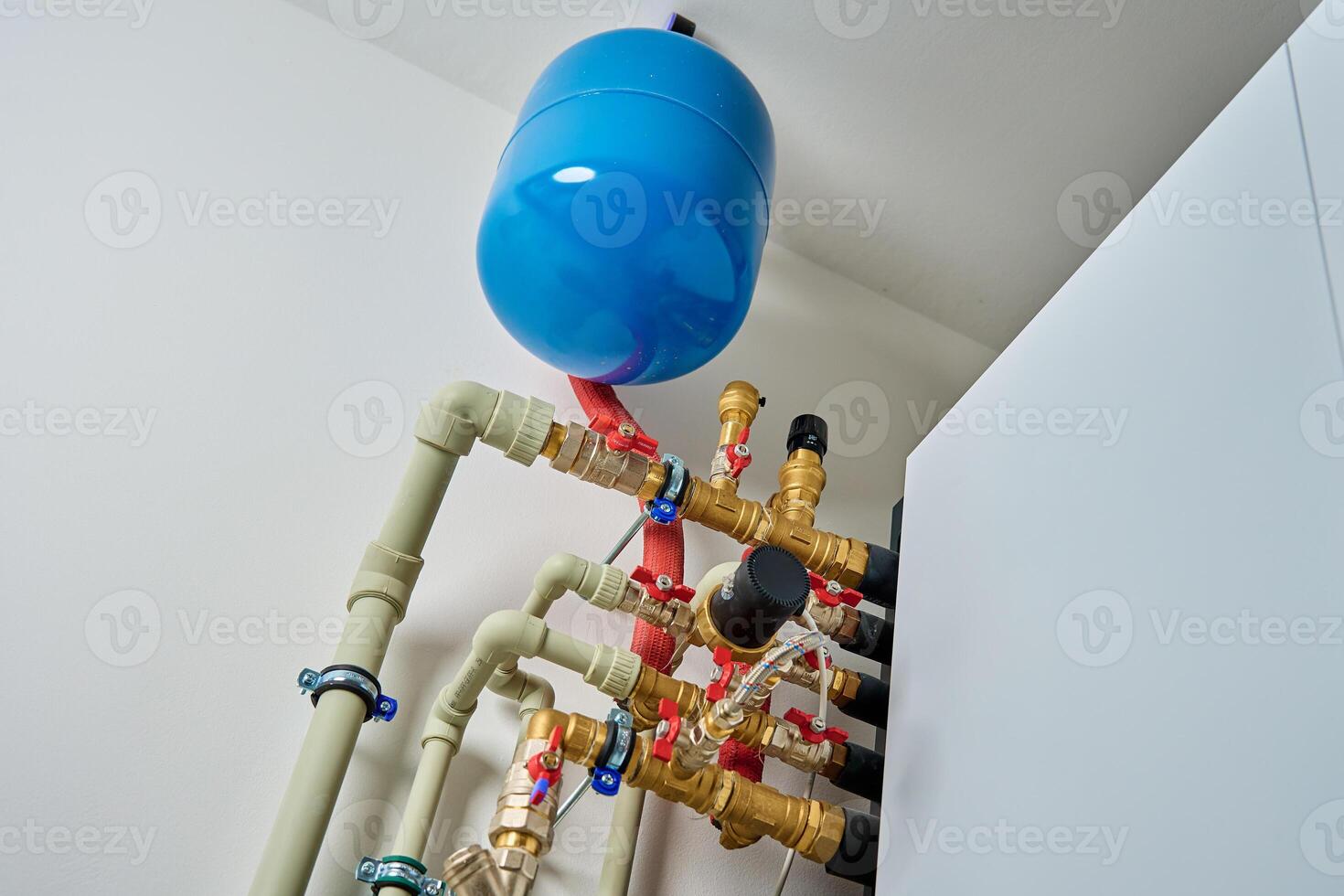 Closed heating system featuring expansion tank, pipes, and shut-off valves, ensuring efficient thermal expansion control photo