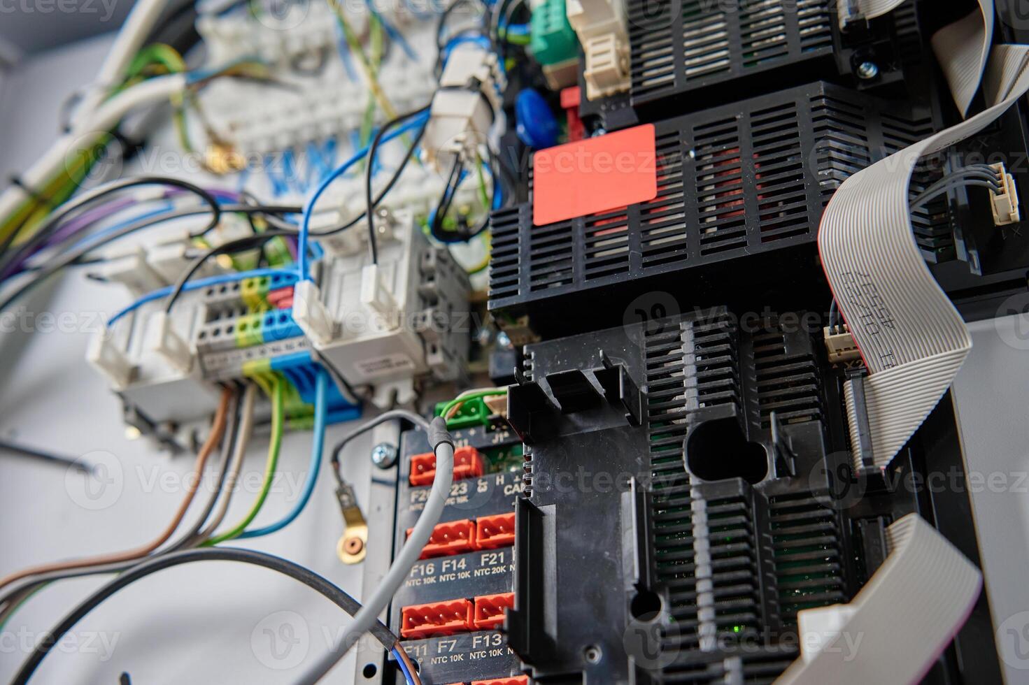 Close-up view of wiring system and circuit board inside electrical control panel. Electrical components used for automation and regulation of various systems photo