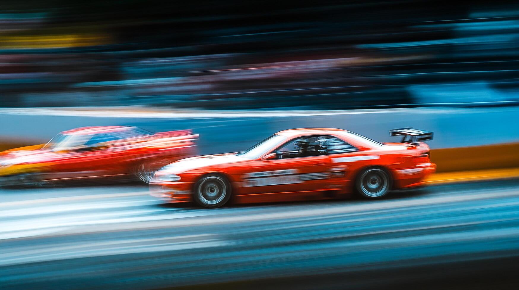 High-speed action captures two vibrant red cars battling for the lead on a racetrack, showcasing incredible speed and competition. photo