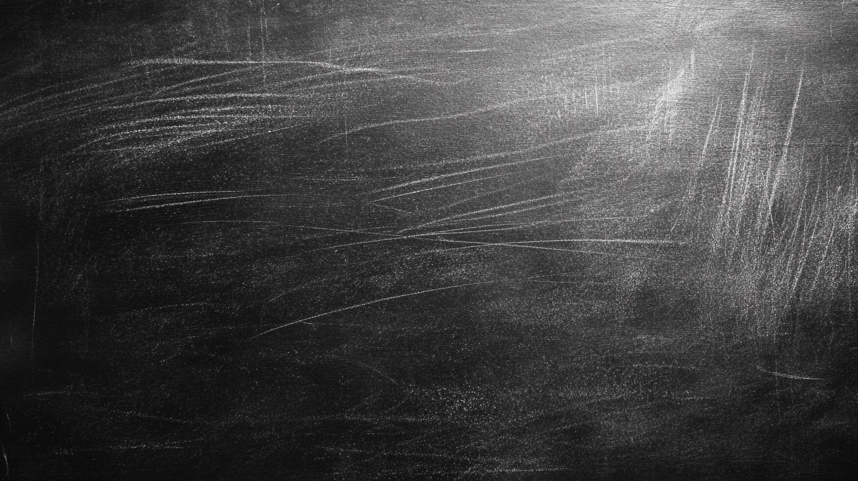 A used black chalkboard. It has white chalk marks and smudges all over its surface. The board is covered in scratches and has a worn surface. photo