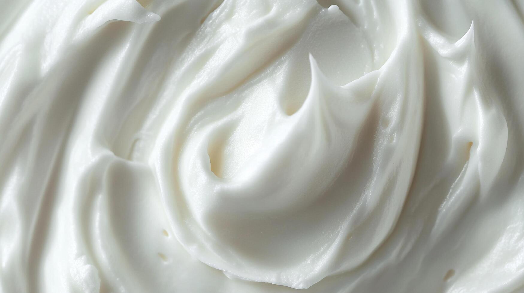 A close-up reveals the smooth, glossy texture of thick, white cream, swirled in a visually appealing way. Perfect for food, skincare, or art. photo