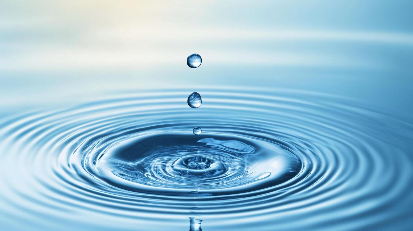 Water droplets create concentric ripples on a pale blue surface, creating a calming, beautiful pattern as each drop penetrates the surface. photo