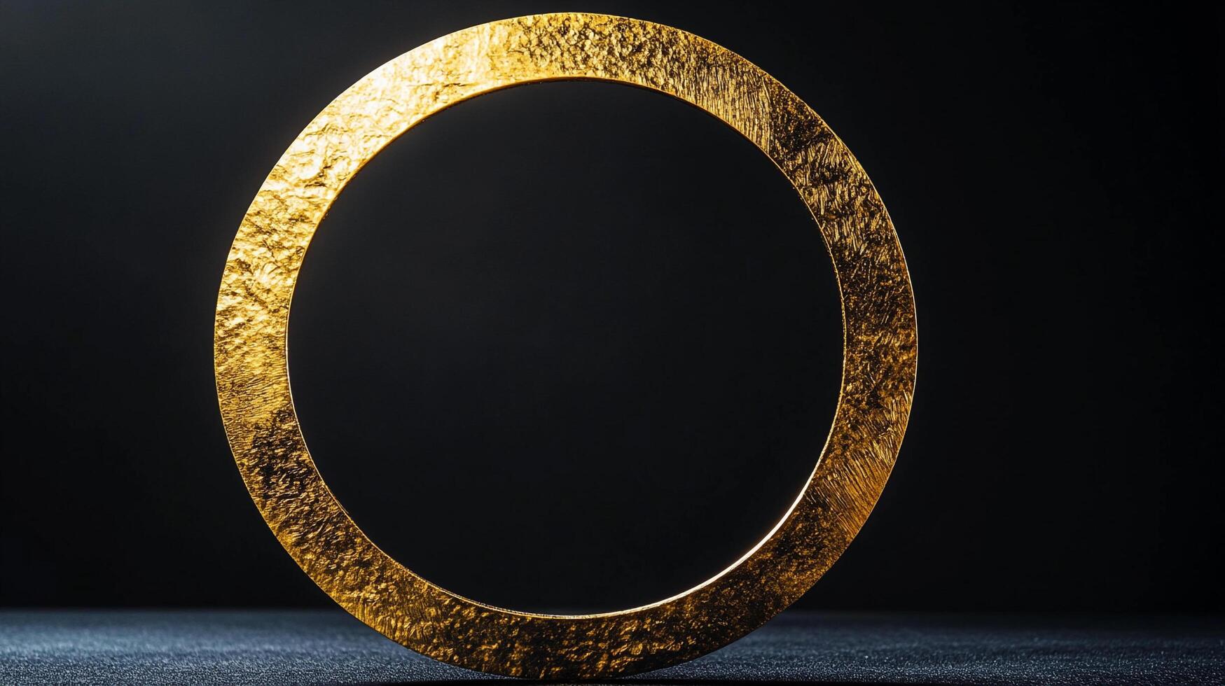 A striking golden circle with a textured surface, dramatically lit against a deep black backdrop, evokes opulence and timeless beauty. photo