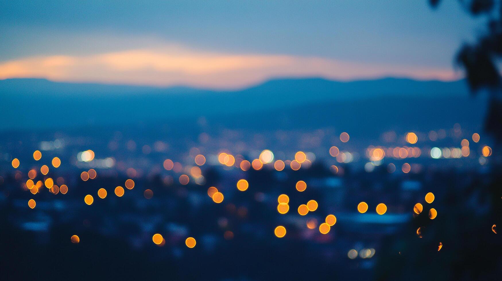 City lights blur in the twilight, orange and yellow against the blue hour sky, creating a dreamy, atmospheric landscape. photo