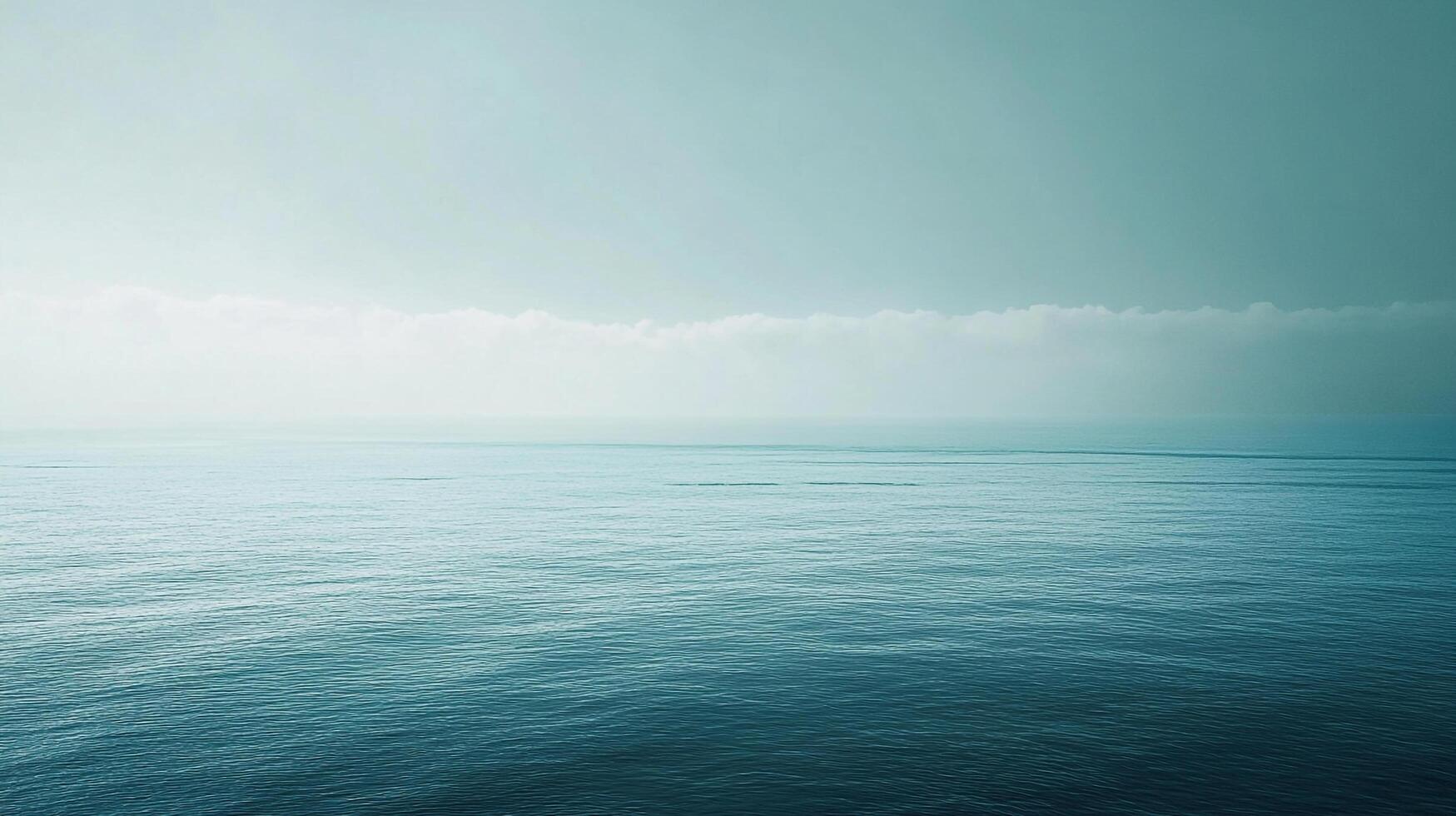 Serene seascape with turquoise water meeting a hazy, cloud-veiled horizon, evokes tranquility and peace with its calming blue tones. photo