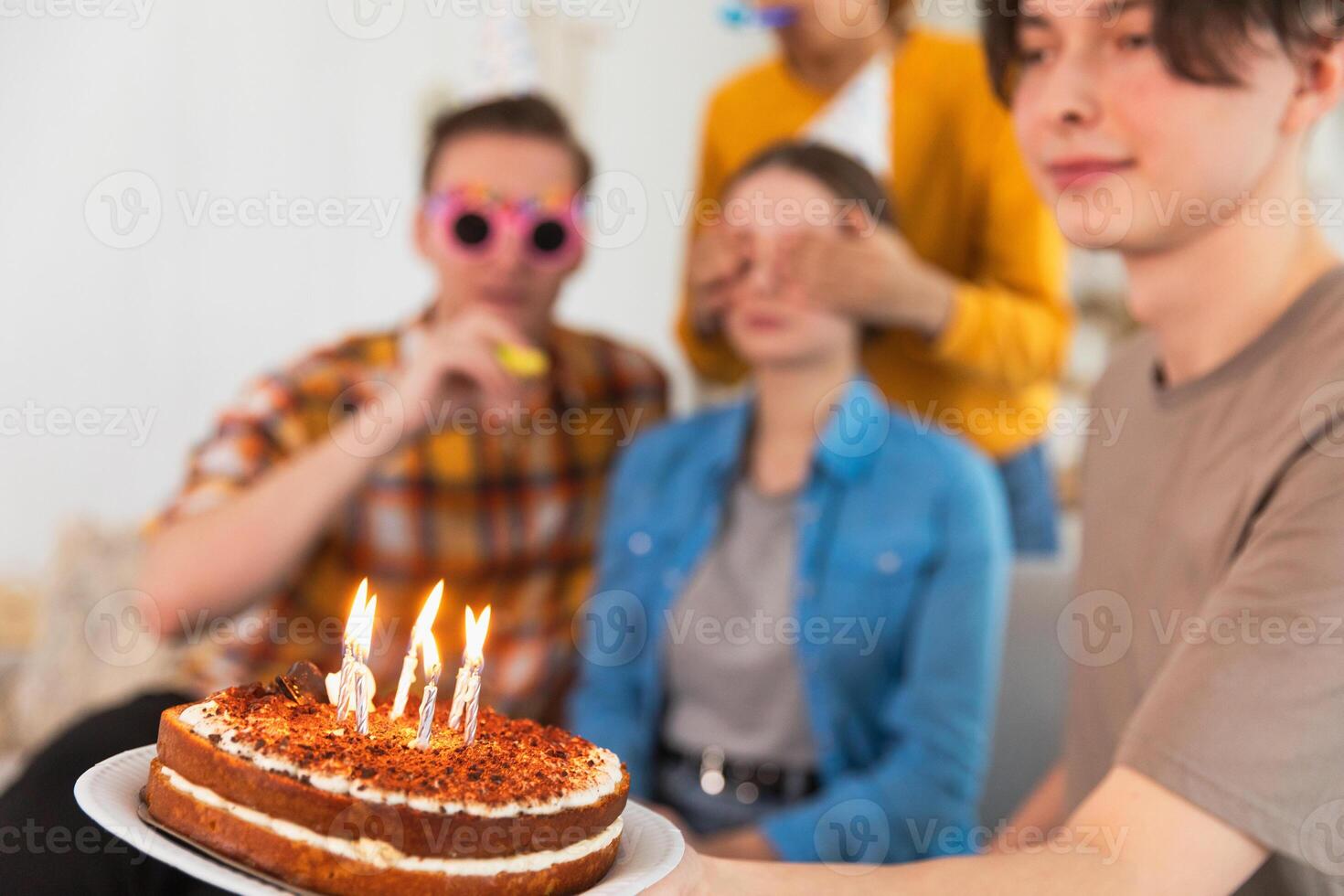 Make a wish. Burning candles on birthday cake ready for blowing out. Happy Birthday party. Friends wishes woman happy birthday. People celebrating birthday party. Plate with birthday cake in hands photo