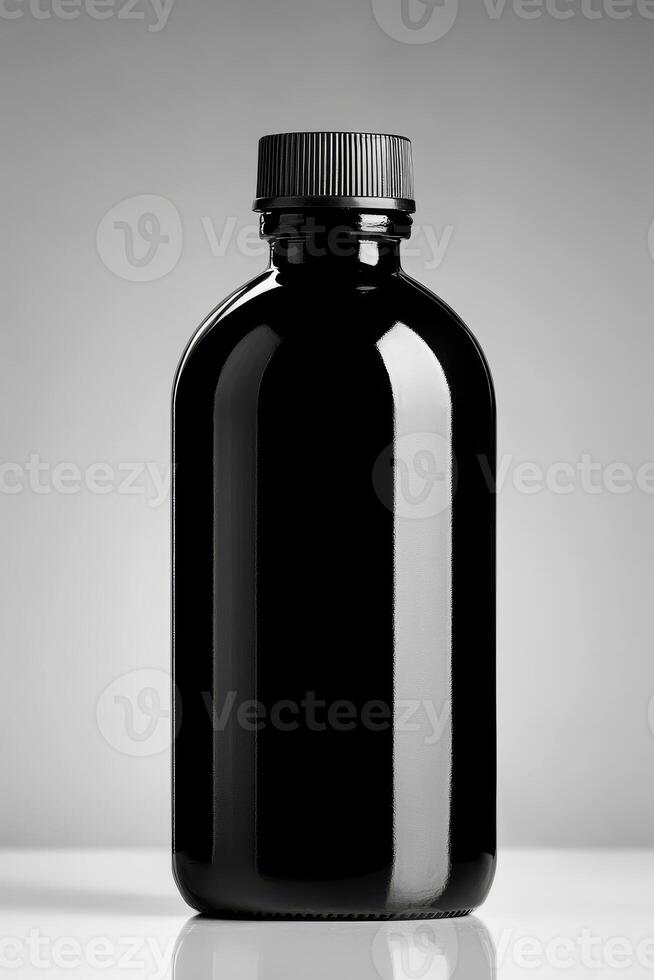Black glass bottle with screw top on a light background photo