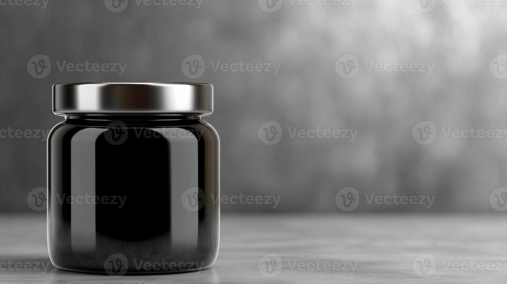 Black glass jar on a grey surface with subtle background texture photo