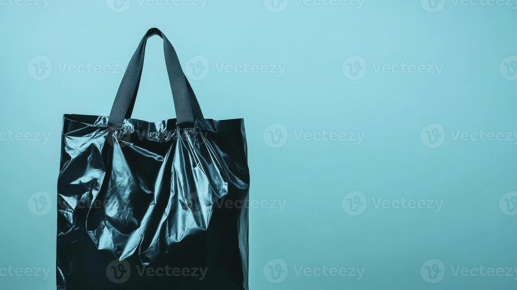 Stylish black bag against a turquoise background showcases minimalism photo