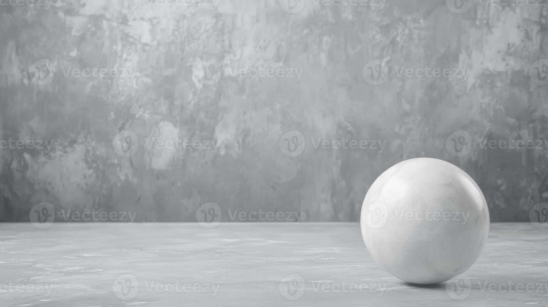 White sphere rests on textured gray surface in minimal setting photo