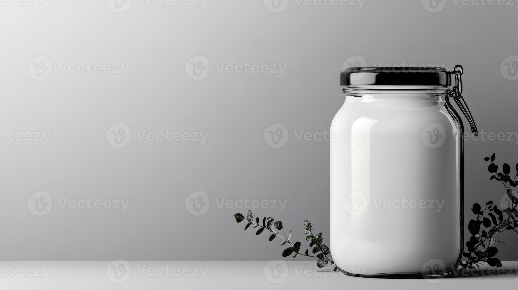 Sleek jar contains a creamy substance beside delicate green leaves photo