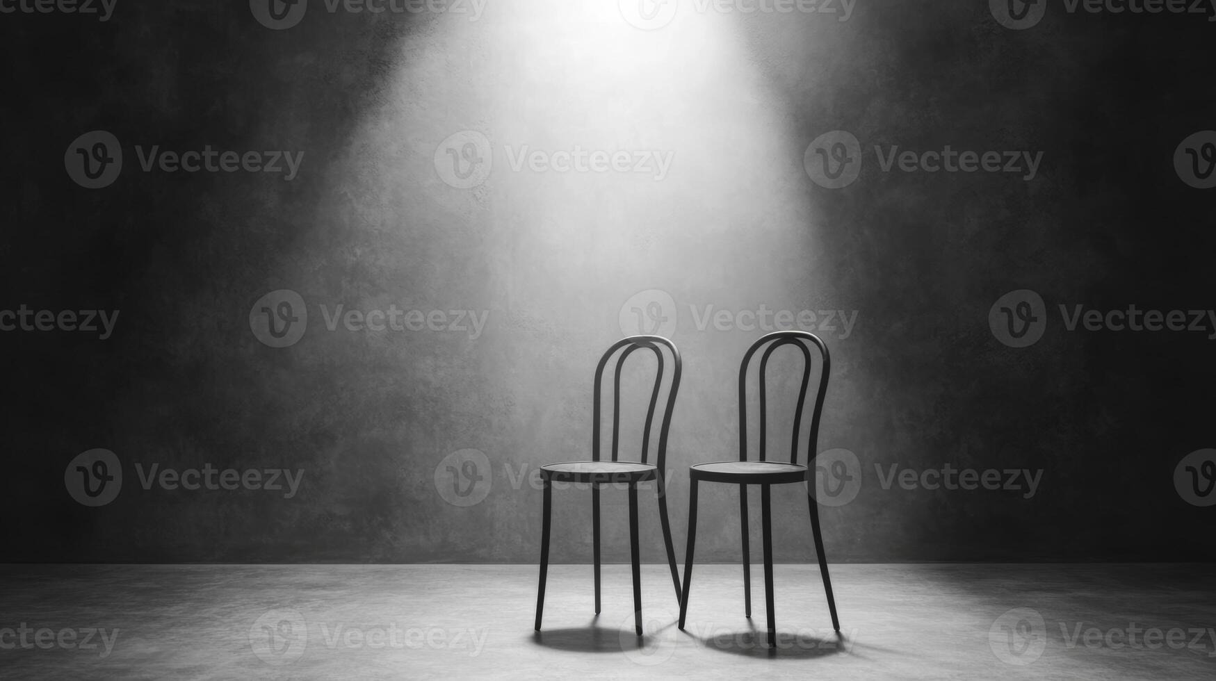 Two elegant chairs illuminated in a stark and moody setting photo