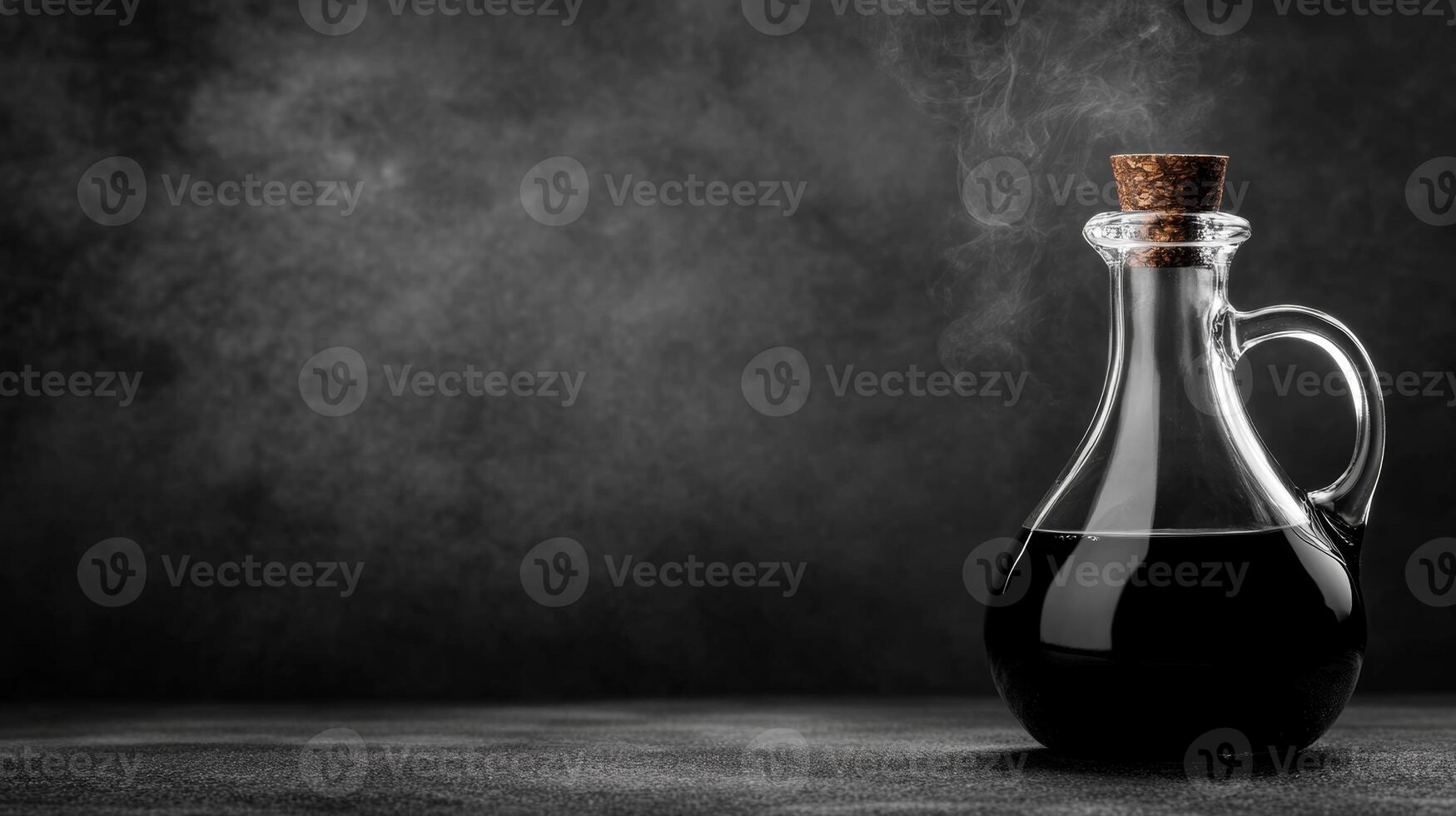 Dark liquid in an elegant glass decanter with a cork stopper photo