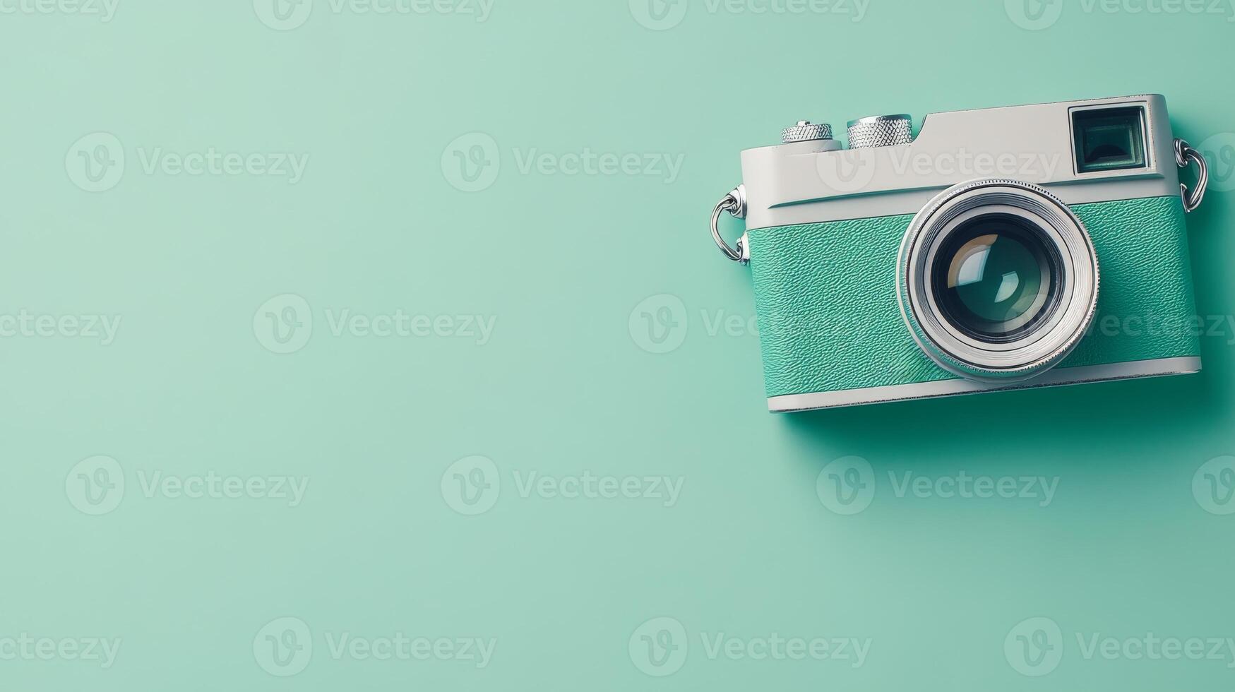 Vintage style camera resting on a teal background photo