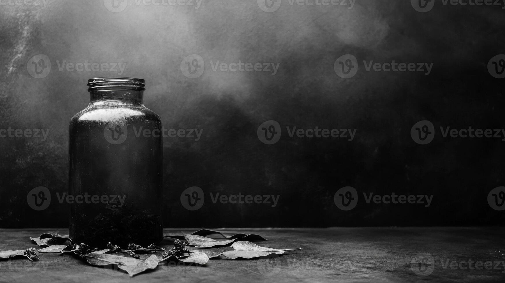Dark glass jar with leaves on a textured surface photo