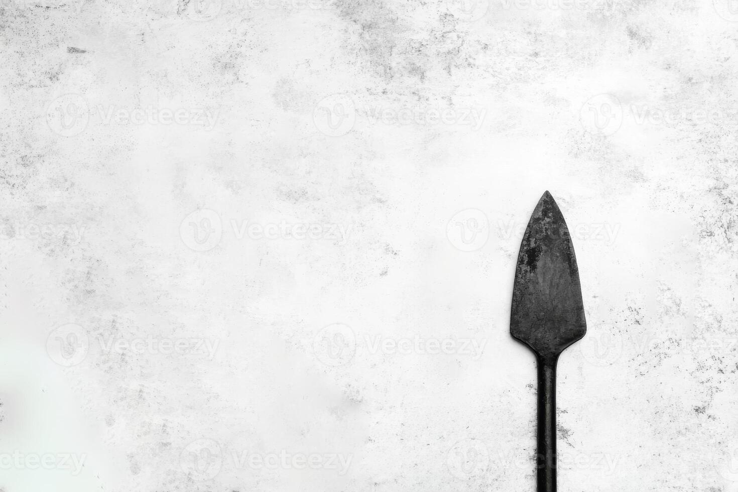 Simple black garden spade on a textured background photo