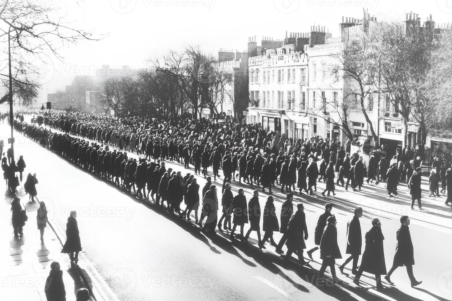 A busy street scene with a large group of people crossing at a pedestrian crossing, showcasing the hustle and bustle of city life photo