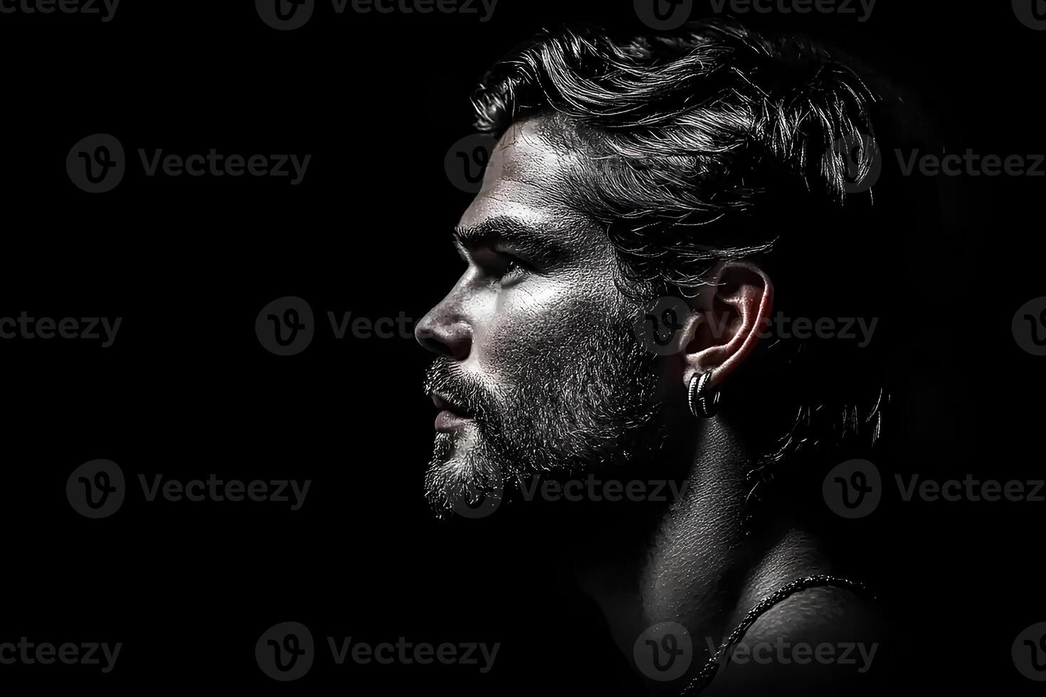 Striking studio portrait of a bearded man against a black background, highlighting his strong features and dramatic lighting photo