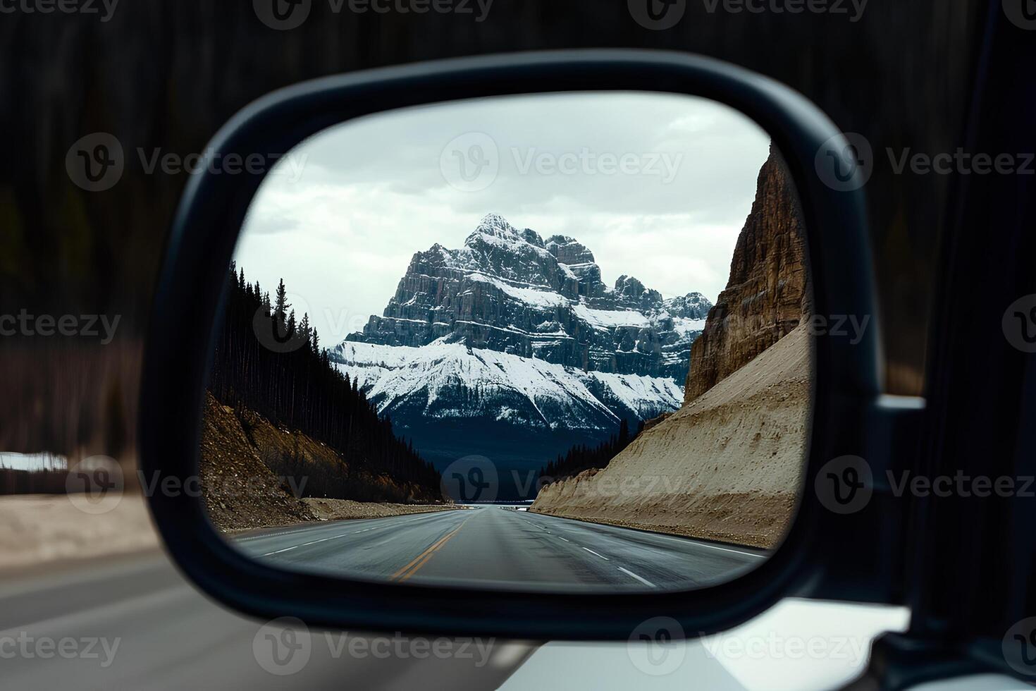 Stunning reflection of mountains in the side mirror of a car, capturing the essence of adventure and freedom on a road trip photo
