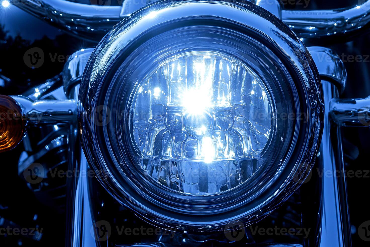 Close-up shot of the headlight on a vintage motorcycle with a cool blue tone, showcasing its classic design and reflective surface photo