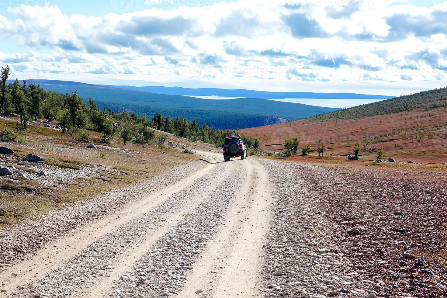 A rugged dirt road winding through the majestic mountains of Yakutia, Russia. The remote and untamed landscape showcases the vast, wild beauty of this northern region photo