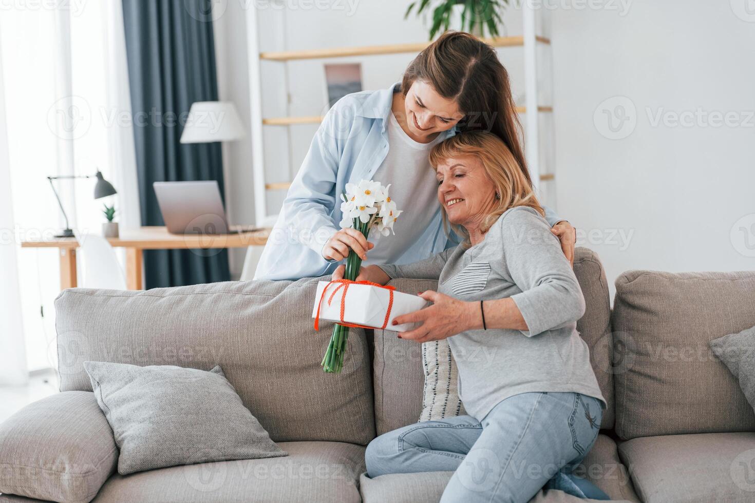 A woman is giving a bouquet to her mother photo