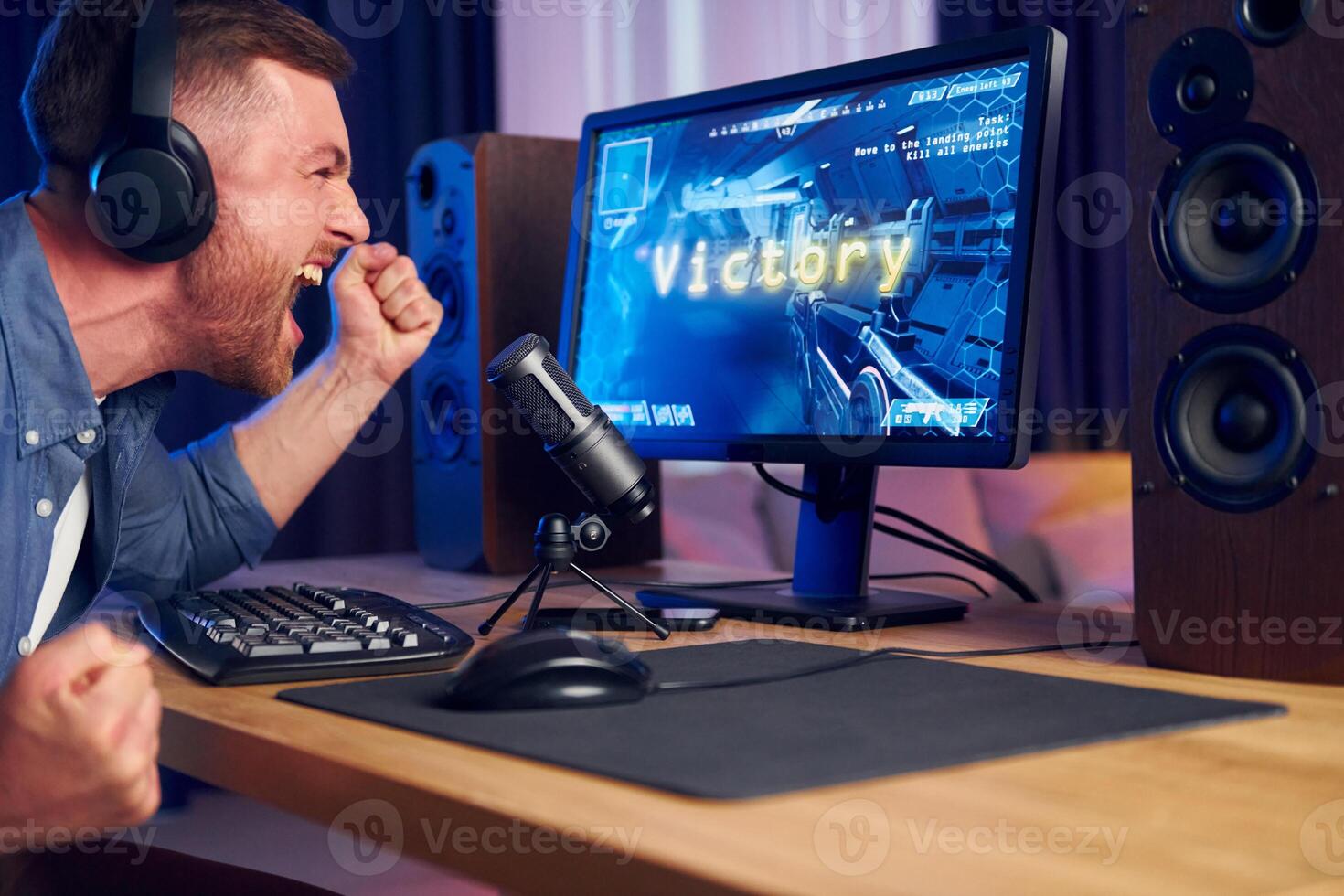 A man is sitting in front of a computer with headphones on photo